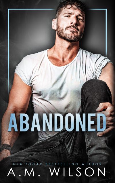 Ebook cover for Abandoned. Male model with dark hair and dark facial hair sitting on the ground with his hand around his knee. Wearing jeans and a wet, white tee shirt